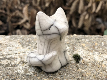Sitting white wolf raku guardian spirit guide sculpture with a kind and gentle face.