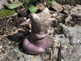 Raku ceramic kitsune fox sculpture. She has sweet praying hands and a gentle, upturned face. She is glazed in a warm, pale brown with soft mauve pink on her tail and lower half.
