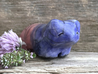 Ceramic raku bear kami sculpture glazed in a front-to-back gradient of indigo blue to soft red-pink. It has a kind, gentle face.