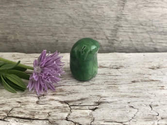 A sweet, tiny kodama nature and forest spirit kami ceramic raku sculpture glazed in an emerald green colour with a happy, gentle smiling face.