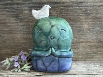Shinto Jizo nature spirit guardian ceramic statue glazed in a bottom-to-top gradient of blue and green with a happy, smiley face, little praying hands, and a sweet white bird on their head.