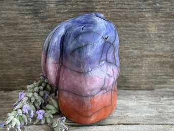 Raku ceramic usagi rabbit kami nature spirit glazed in a bottom-to-top gradient of burnt orange to mauve to indigo-violet. Its ears are folded down its back, and it has a kind, gentle face.