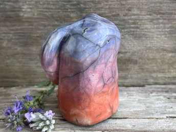 Raku ceramic usagi rabbit kami nature spirit glazed in a bottom-to-top gradient of burnt orange to mauve to blue-violet. Its ears are folded down its back, and it has a kind, gentle face.