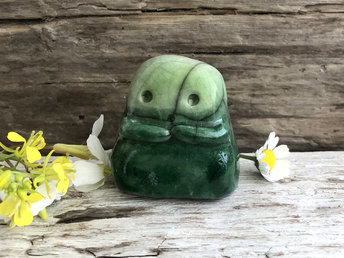 A sweet little kodama nature spirit ceramic guardian statue glazed in shades of green and with a lovely, gentle face and little arms.