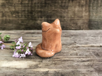 A sweet little Shinto Inari sitting kitsune fox kami spirit ceramic raku statue glazed in a warm orange colour.