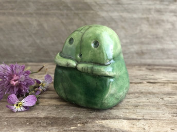 A sweet little kodama nature spirit ceramic guardian statue glazed in shades of green and with a lovely, gentle face and little arms.