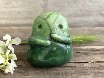 A sweet little kodama nature spirit ceramic guardian statue glazed in shades of green and with a lovely, gentle face and little arms.