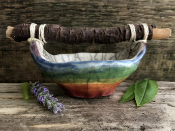 Raku ceramic bucket with a driftwood handle. The bucket is glazed in beautiful rainbow colours on the outisde, and the inside is glazed in white.