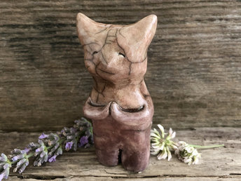 Raku ceramic standing kitsune fox sculpture glazed in soft orange-brown and shades of pink/mauve. He has sweet praying hands, and long tail, and a gentle, kind face.