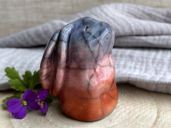 Raku ceramic usagi rabbit kami nature spirit glazed in a bottom-to-top gradient of burnt orange to mauve to soft indigo. Its ears are folded down its back, and it has a kind, gentle face.