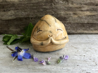 A smiley, loving, and very happy Jizo Shinto raku ceramic sculpture talisman glazed in warm yellow-orange with sweet little praying hands.
