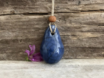 Raku ceramic worry pendant shaped a little like a bendy pear and glazed in blue. It has a sandalwood bead above it and is strung on a flax cord.