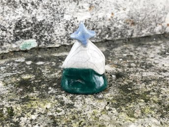 Ceramic raku winter tree sculpture. This little green fir tree statue has a white-glaze top like thick snow and a small blue star on top. Lovely decoration for winter solstice, Christmas, Yule.