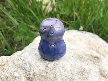 A smiley, loving, and very happy Jizo Shinto raku ceramic sculpture talisman in violet and purple. A wonderful smooth shape to hold in the hand.