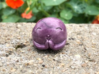 A smiley, loving, and very happy round Jizo Shinto raku ceramic sculpture talisman glazed in purple with sweet little praying hands.