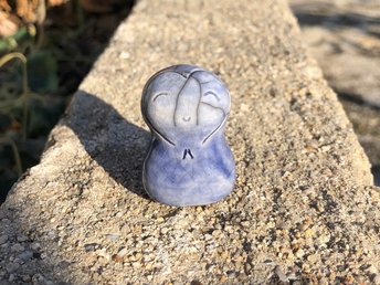 A smiley, loving, and very happy Jizo Shinto raku ceramic sculpture talisman in pale blue with a heart shape around her face. A wonderful smooth shape to hold in the hand.