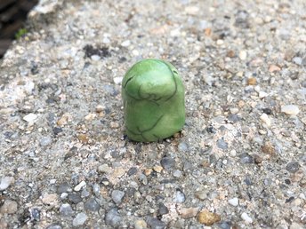 A sweet, tiny kodama nature and forest spirit kami ceramic raku sculpture glazed in a soft green colour with a happy, gentle smiling face. Lovely for a Shinto kamidana shrine, pagan altar, shamanism.