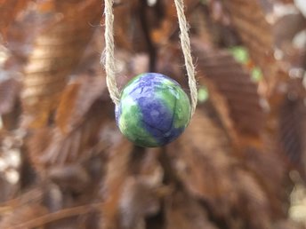 Beautiful raku ceramic spherical bead glazed in blue and green like the earth and strung on an adjustable eco-hemp cord. Lovely pendant necklace for earth healing or rewilding.