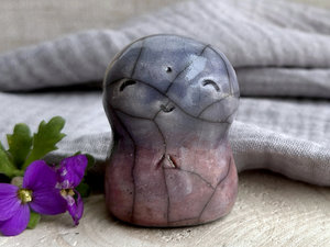 A smiley and loving Jizo Shinto raku ceramic sculpture talisman glazed in a bottom-to-top gradient of violet (with hints of soft orange) to blue. It has a kind, gentle face and is a wonderful smooth shape to hold in the hand.