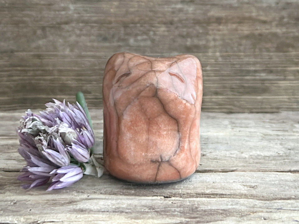 very small raku ceramic fox sculpture glazed in a warm peach colour. it has a gentle face.